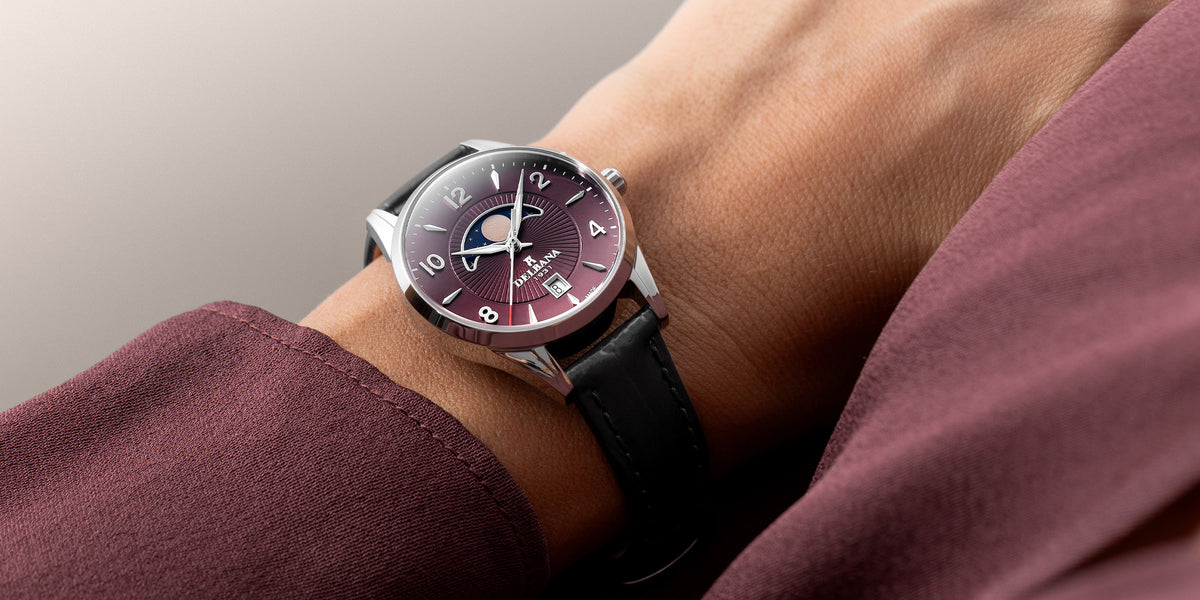 Delbana Lunetta stainless steel moonphase watch with burgundy dial and black leather strap on wrist
