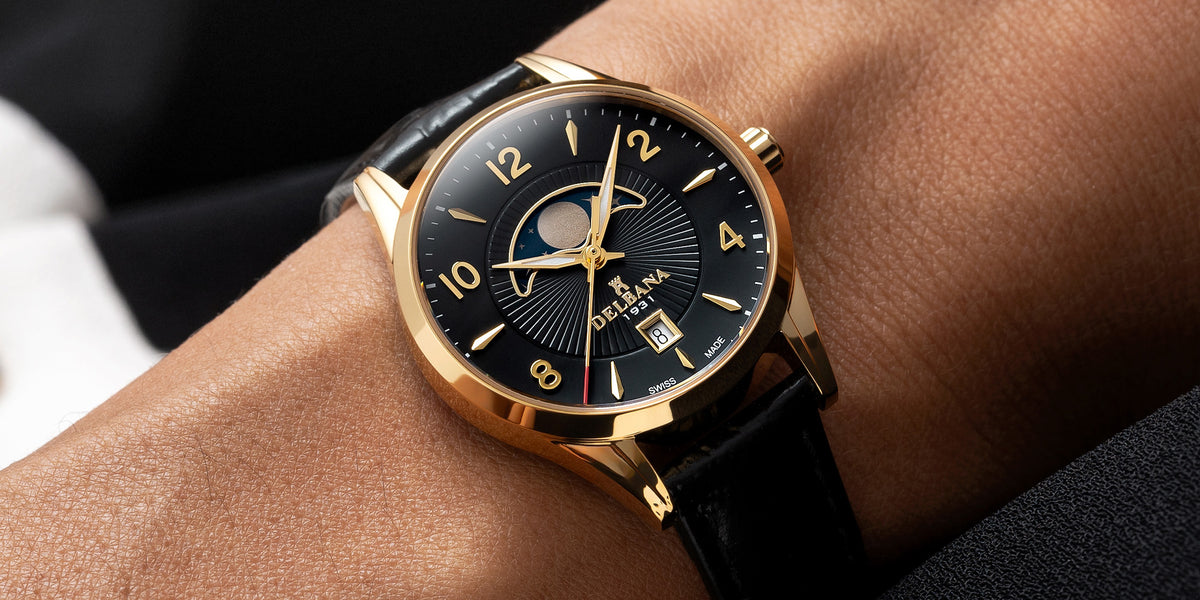 Delbana Lunetta stainless steel with yellow gold PVD moonphase watch with black dial and black leather strap on wrist